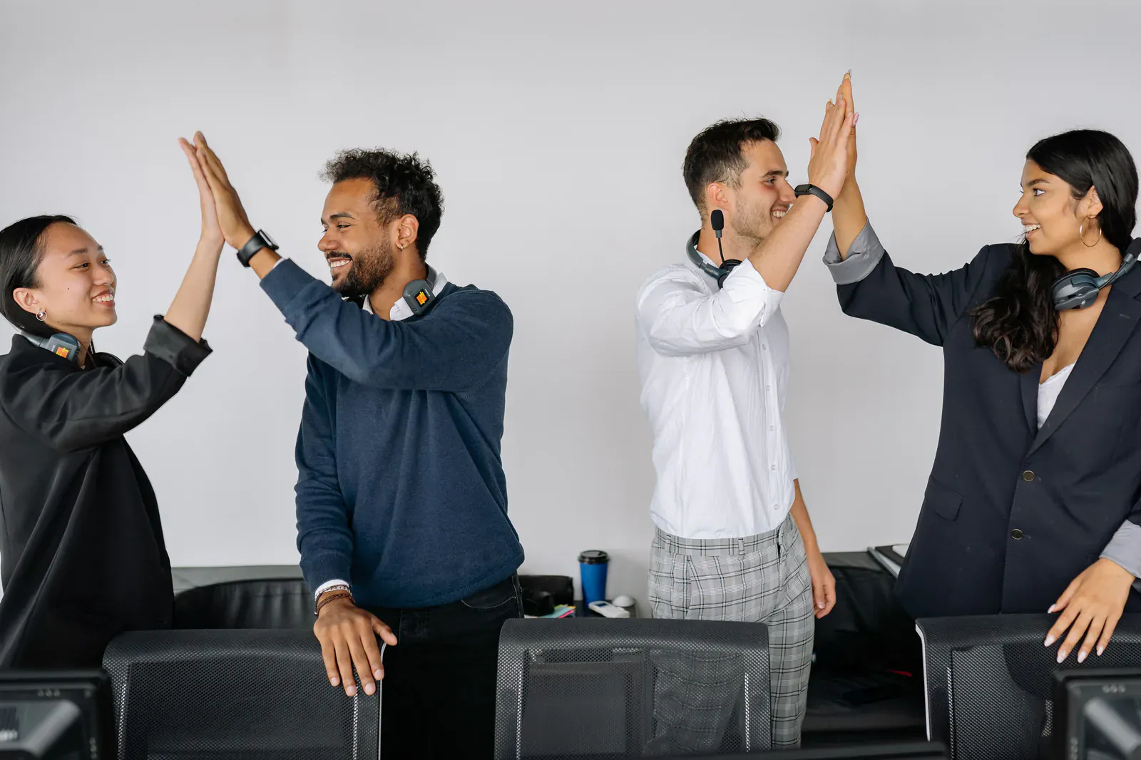 Four colleagues celebrating with high fives